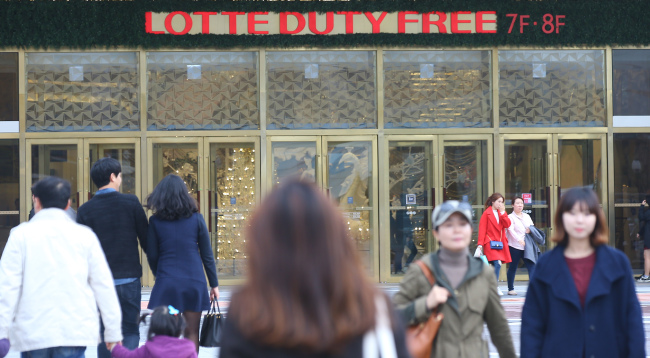 People walk past the Lotte Duty Free store at Lotte World Tower in Gangnam, Seoul.   Yonhap