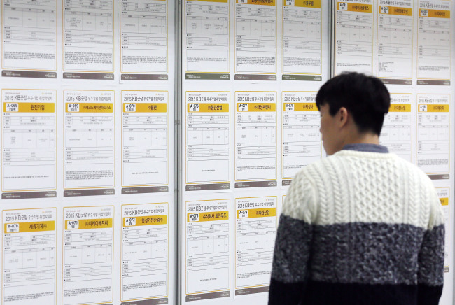 A young jobseeker looks at a job posting on a bulletin board. Yonhap