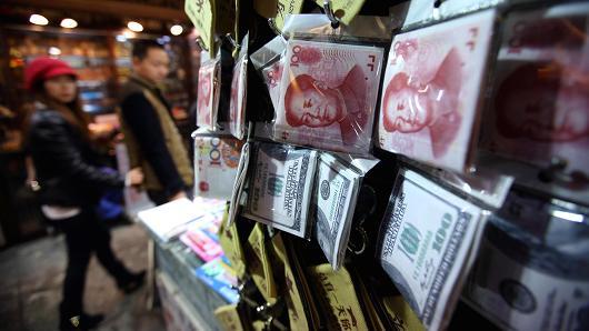 Wallets with images of the yuan and dollar banknotes displayed at a store in Beijing (Bloomberg)