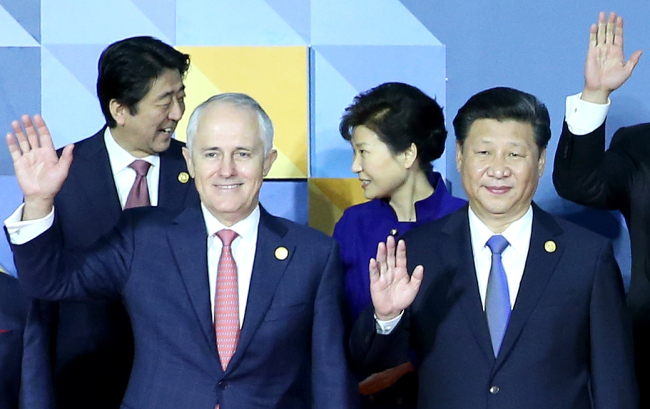 President Park Geun-hye (right, back row) talks with Japanese Prime Minister Shinzo Abe (left, back row) as they stand for a photo session at the Asia-Pacific Economic Cooperation summit in Manila, the Philippines, Thursday. (Yonhap)