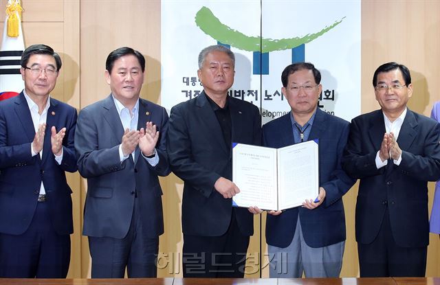 경제사회발전노사정위원회 김대환 위원장 등 위원들이 지난 9월 15일 정부서울청사 노사정위 대회의실에서 제89차 본위원회를 열어 ‘노동시장 구조개선을 위한 노사정 합의문을 만장일치로 의결한뒤 포즈를 취하고 있다. 왼쪽부터 이기권 고용노동부 장관, 최경환 부총리 겸 기획재정부 장관, 김동만 한국노총 위원장, 박병원 한국경총 회장, 김대환 위원장. [사진=헤럴드경제DB]