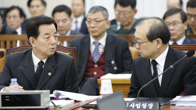 Defense Minister Han Min-koo(left) and Chang Myoung-jin, the head of the Defense Acquisition Program Administration, attend a parliamentary session on Wednesday.(Yonhap)