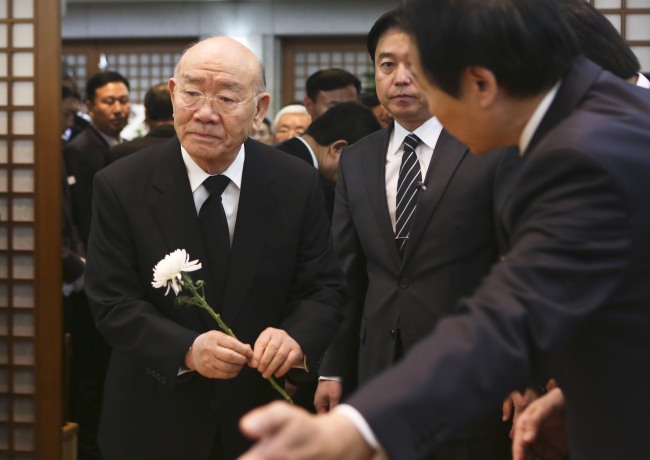 Former President Chun Doo-hwan holds flower to pay respects for the late former President Kim Young-sam, a democratic fighter who fought against him, at a funeral hall in Seoul. (Yonhap)