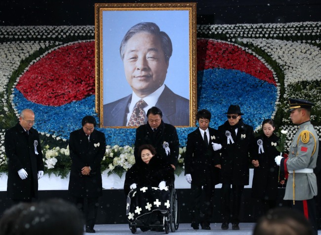 Bereaved family members of late former President Kim Young-sam, including former first lady Son Myung-soon (in the wheelchair), return after offering flowers Thursday at a state funeral held at the National Assembly. (Yonhap)