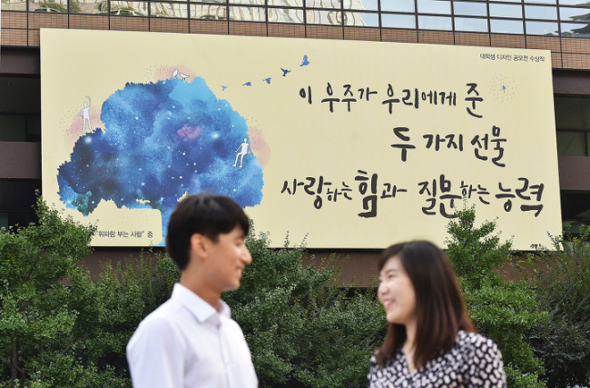The Kyobo Life Insurance billboard featuring a quote from an essay by American poet Mary Oliver is hung at the firm’s headquarters in central Seoul. It reads “In this universe we are given two gifts: the ability to love and the ability to question.” (Kyobo Life Insurance)