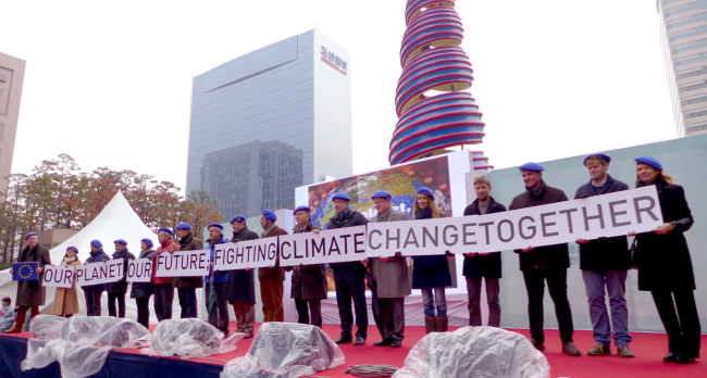 Eighteen EU diplomats take part in an event in Seoul on Sunday intended to raise awareness for the 2015 United Nations Climate Change Conference in Paris. They walked with environmental organizations and citizens along the Cheonggyecheon Stream in downtown Seoul and participated in concerts.  Joel Lee/The Korea Herald
