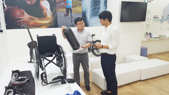 전북창조경제혁신센터에 위치한 탄소섬유제품 전시실에서 한 방문객이 CNG연료탱크와 관련 직원의 설명을 듣고 있다.