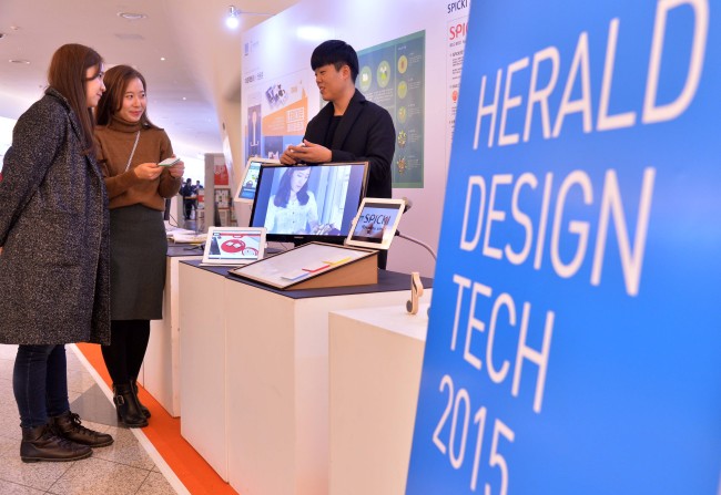 Visitors to the Herald Design Tech booth inside DDP in Seoul learn about Spiki, a plastic recording device resembling a Post-it note on Wednesday. (Lee Sang-sub/The Korea Herald)