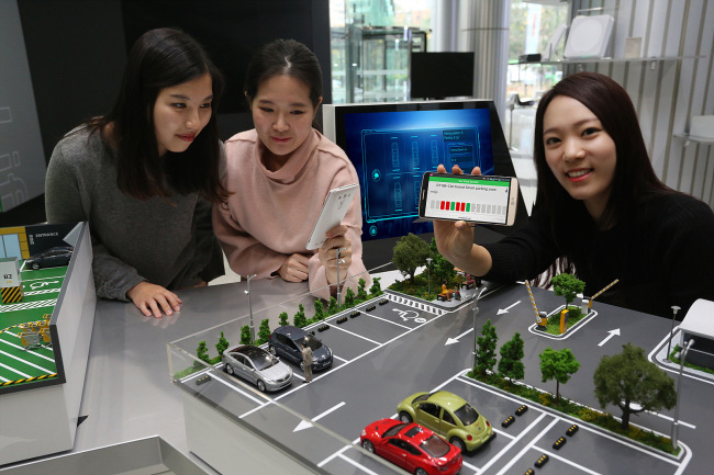 LG Uplus staffers pose with a smart parking solution utilizing the firm's LTE technology. (LG Uplus)
