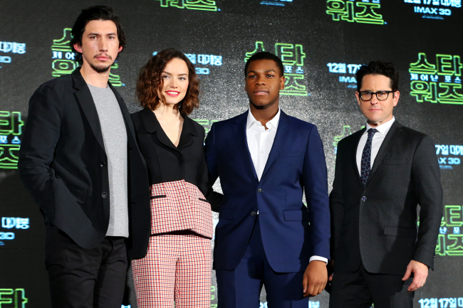 J.J. Abrams (right) poses for a photo with actors from “Star Wars: The Force Awakens” ahead of a press conference in Seoul on Wednesday. From left: Adam Driver, Daisy Ridley, and John Boyega.   Yonhap