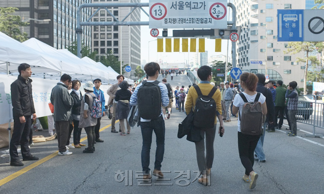 사실 태어날 때부터 ‘사람의 다리’였던 것은 아닐까. 남대문시장에서 출발해 왼발은 중림동, 오른발은 만리재를 향해 양발을 뻗고 있다. 천상 ‘사람 인(人)’의 모습이다. 서울역 고가차도. 이는 그냥 콘크리트 덩어리가 아니다. 지난 45년간 영희 아빠, 철수 엄마의 구슬땀과 꿈을 남대문 시장으로 실어나른 삶의 통로이다. 이 고가차도가 13일 0시부터 고가인도로 변신한다.   11일 폐쇄를 앞둔 서울역 고가차도와 지난해 10월12일 잠시 인도로 변신한 서울역 고가에서 시민들이 여유를 즐기는 모습.   박현구 기자/phko@heraldcorp.com