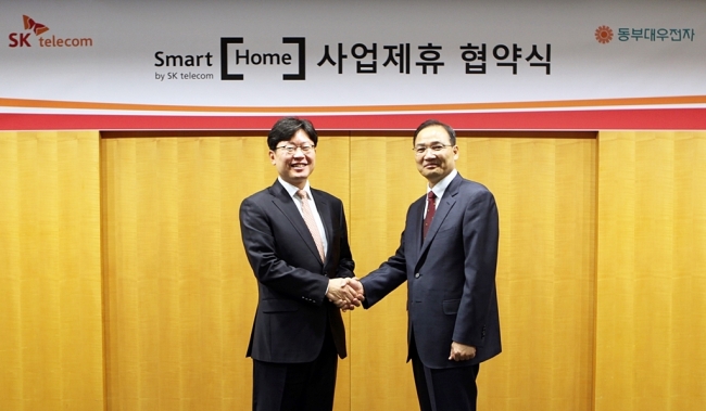 COLLABORATION FOR SMART HOME -- Cho Young-hoon (left), head of SK Telecom‘s smart home TF, and Kim Hyeog-pyo, vice president of Dongbu Daewoo Electronics, pose at the signing ceremony of a memorandum of understanding in Seoul on Tuesday. The mobile carrier and the electronics maker will work together to launch home appliances which can be remotely controlled by SKT’s smartphone apps. (SKT)