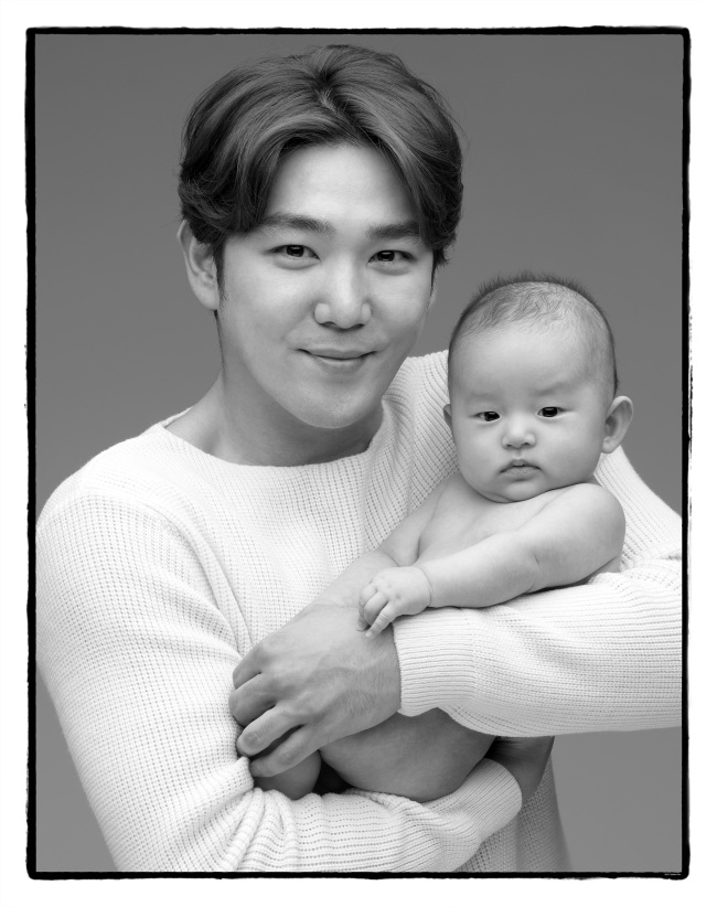Roy Kim poses with a baby. (Photo by Cho Seihon)