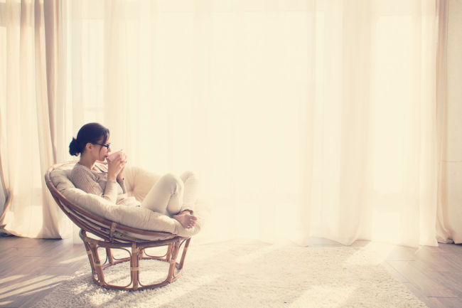 A woman enjoys a cup of coffee at home. (123rf)