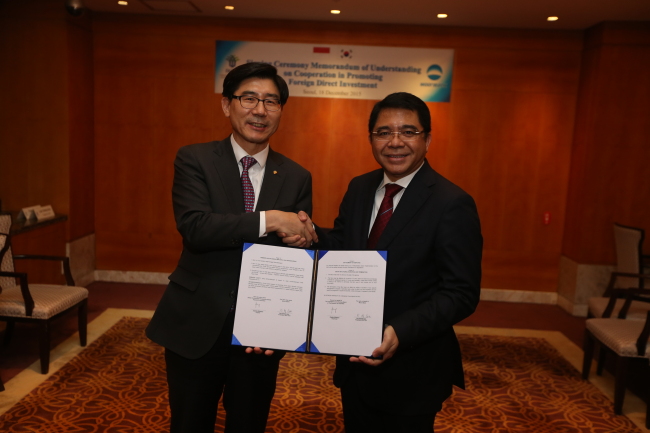 INVESTMENT TIES WITH INDONESIA -- Woori Bank president Lee Kwang-goo (left) poses with Indonesia Investment Coordinating Board chairman Franky Sibarani after signing a mutual cooperative agreement for strategic partnership in downtown Seoul on Friday. (Woori Bank)