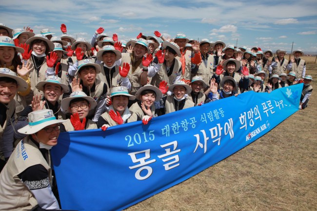 Employees of Korean Air pose for photo after planting trees in the Baganuur Desert in Mongolia.   Korean Air