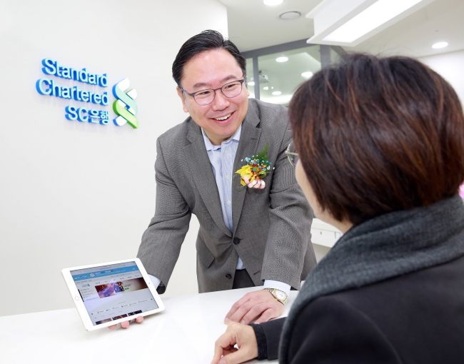 대구 이마트 반야월점에 최근 오픈한 한국SC은행 뱅크샵에서 한국SC은행 리테일금융총괄본부장 윤패트릭 전무가 직접 고객을 응대하고 있다.  [사진제공=한국SC은행]