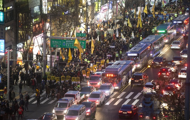 Participants in an antigovernment rally march in Seoul on Dec.5., protesting the government’s labor reform measures and reintroduction of state-authored history textbooks. (Yonhap)