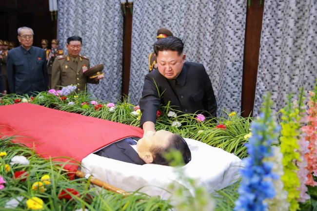 A handout picture provided by North Korea's state-run Rodong Sinmun newspaper on 31 December 2015 shows North Korean leader Kim Jong-un, touching the body of Kim Yang-gon, a secretary of the ruling Workers' Party of Korea and one of his key aides handling inter-Korean affairs, as he visits the mortuary of Kim to pay homage in Pyongyang, North Korea, 30 December 2015. Kim, one of the two ranking North Korean officials who attended the rare inter-Korean high-level talks in August, died in a car accident on 29 December. (Yonhap/Rodong Sinmun)
