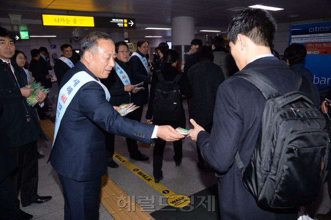 사진위는 이정원 사장이 시민들에게 핫팩을 나눠 주고 있다. 아래는 이정원 사장을 비롯 임원들이 소망나무에 메달편지를 쓰고 있다.