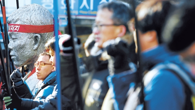 Members of the Korea Confederation of Trade Unions announce this year’s plan to fight the government’s push for labor market reforms near the statue of Jeon Tae-il, a deceased labor activist, along the Cheonggyecheon Stream in central Seoul, Monday. (Yonhap)