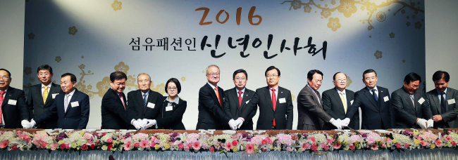 <YONHAP PHOTO-3130> 2016 섬유패션인 신년인사회 (서울=연합뉴스) 윤상직 산업통상자원부 장관(오른쪽에서 일곱번째)을 비롯한 섬유패션업계 관계자들이 5일 오후 서울 삼성동 섬유센터에서 열린 2016 섬유패션인 신년인사회에서 축하떡을 자르고 있다. 2016.1.5 << 산업통상자원부제공 >> photo@yna.co.kr/2016-01-05 20:53:11/ <저작권자 ⓒ 1980-2016 ㈜연합뉴스. 무단 전재 재배포 금지.>