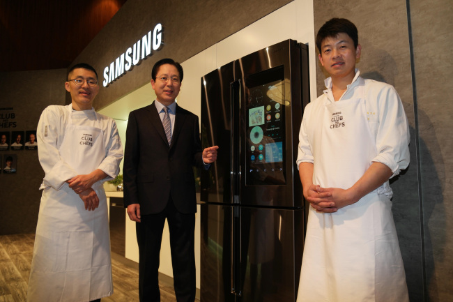 SAMSUNG SMART FRIDGE -- Seo Byung-sam (center), senior vice president of Samsung Electronics, poses Wednesday with chefs to promote the Chef Collection Family Hub refrigerator, equipped with a 21.5-inch touch screen display that allows users to do online shopping and monitor the status of storage spaces, at the International CES trade show.　(Samsung)