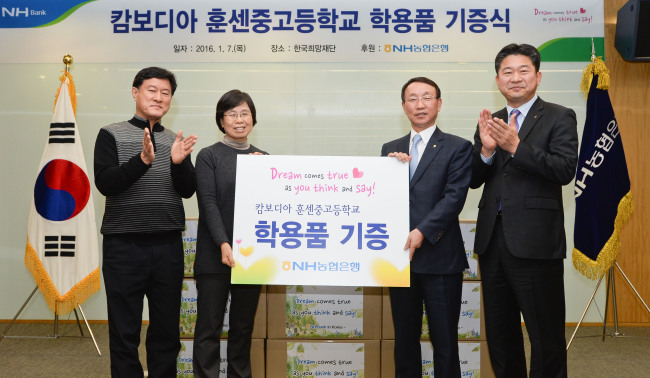 NH농협은행 김호민 수석부행장(오른쪽 두번째)이 한국희망재단 이철승 상임이사(왼쪽 두번째)에게 학용품을 전달하며 기념촬영을 하고 있다.
