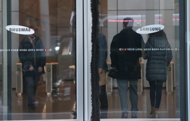 Samsung employees enter the company's office in southern Seoul on Friday. Yonhap