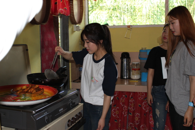 A participating student of the homestay program is cooking a traditional Malaysian dish at her host family‘s house. Yoon Min-sik/The Korea Herald