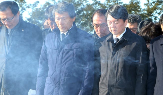Independent Rep. Ahn Cheol-soo (right) and professor Han Sang-jin (center), cochairman of the party preparatory committee, pay respects at the cemetery of late President Roh Moo-hyun in Bongha Village, South Gyeongsang Province, Tuesday.   Yonhap