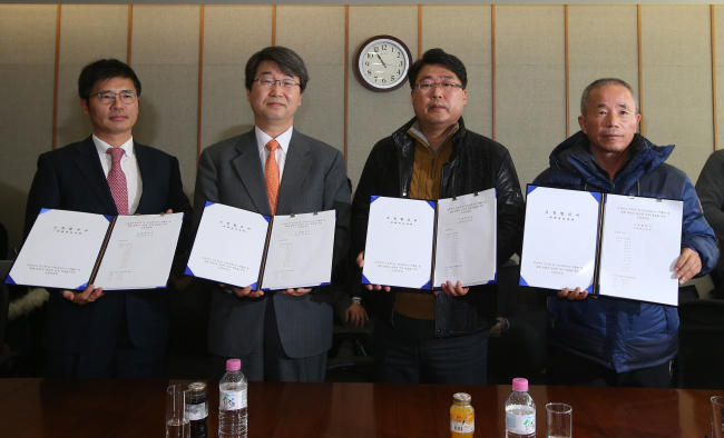 (From left)Baek Soo-hyun, a senior vice president of Samsung Electronics, Kim Ji-hyeong, head of the mediation body for Samsung’s leukemia dispute, Song Chang-ho, a representative of the group for leukemia victims’ families, and Hwang Sang-ki, head of advocacy group Banolim pose in Seoul Monday after the three parties reached an agreement on preventive measures for workers at the firm’s chip and display factories.