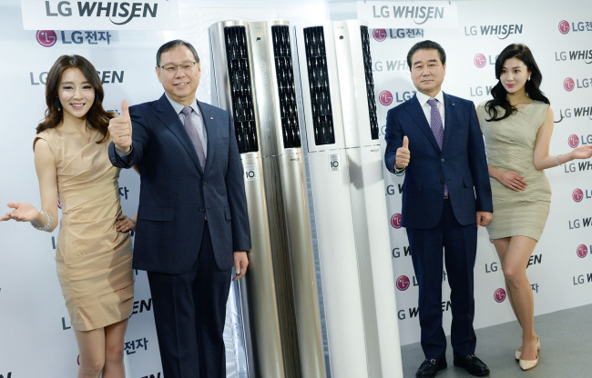 COOL NEW AIR CONDITIONERS -- Cho Sung-jin (second from left), head of LG Electronics’ home appliance and air solution business unit, and Choi Sang-gyu (second from right), head of the firm’s Korea sales and marketing, pose at the unveiling event of the tech firm’s 2016 Whisen Dual Air Conditioner lineup, fitted with two cold air outlets, motion sensors and air purifying and dehumidifying functions.　(LGE)