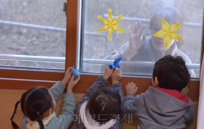 누리과정 예산 미편성 사태로 학부모들의 불안이 점점 높아지는 가운데 서울의 한 어린이집에서 잠시라도 헤어지기 싫어하는 아이가 엄마와 창문 너머로 인사를 나누고 있다. 정희조 기자/checho@heraldcorp.com