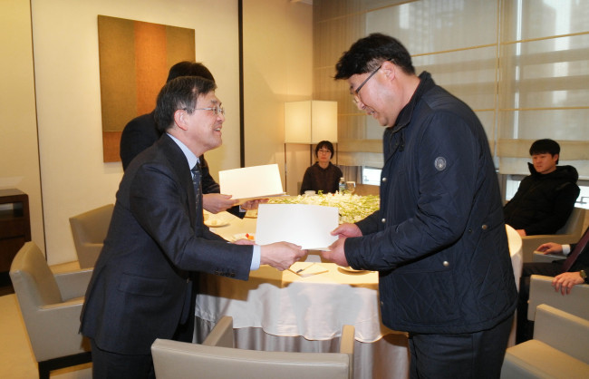 Samsung Electronics CEO Kwon Oh-hyun hands a written apology to Song Chang-ho, a representative of the group for leukemia victims’ families, at the firm’s head office in Seoul on Thursday.   Samsung Electronics