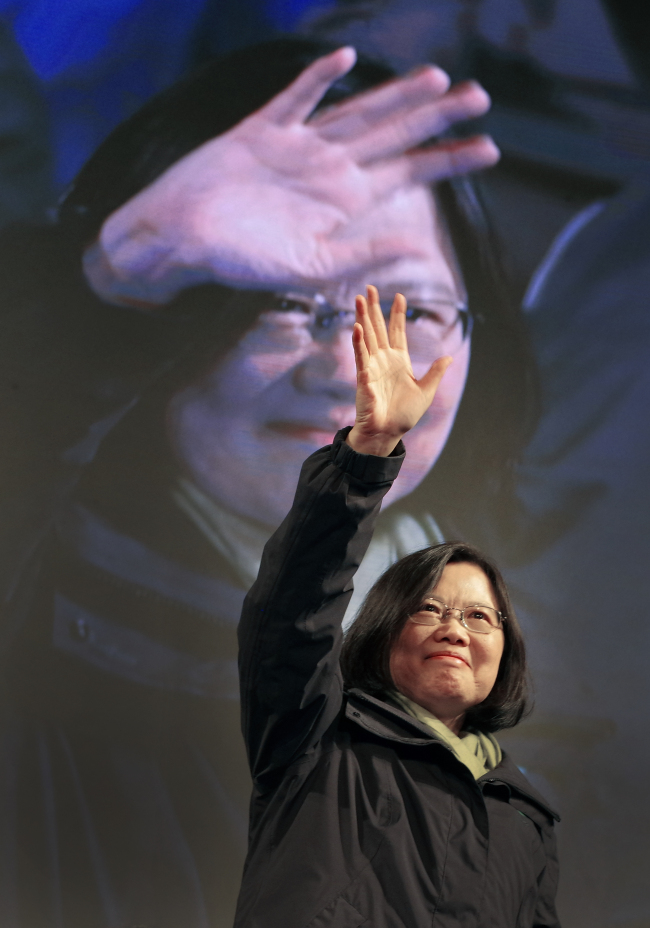 Taiwan’s Democratic Progressive Party candidate Tsai Ing-wen raises her hands as she declares victory in the presidential election in Taipei on Saturday.   AP-Yonhap
