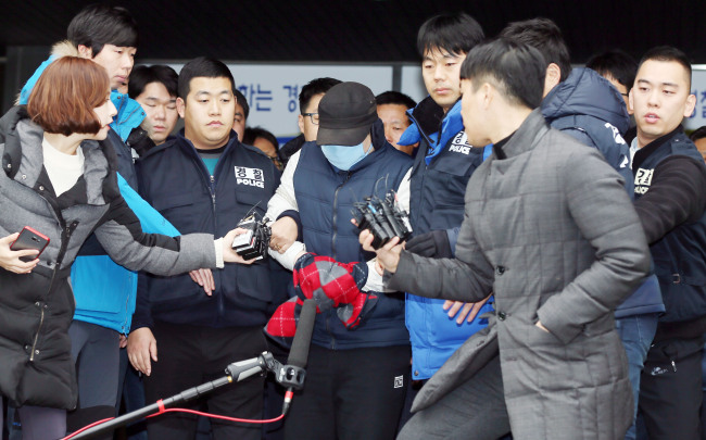 A father, who has been arrested on charges of mutilating the body of his seven-year-old son, steps out of a police station in Bucheon, Gyeonggi Province, Sunday.  Yonhap.
