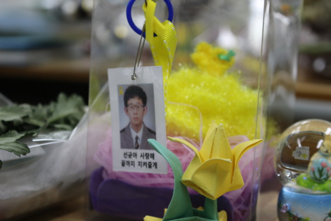 A photo of a student victim is hung on a box of gifts left at his desk. Below the photo is the message “Seongyun, I love you. I’ll protect you to the end.” (Yoon Min-sik/The Korea Herald)
　