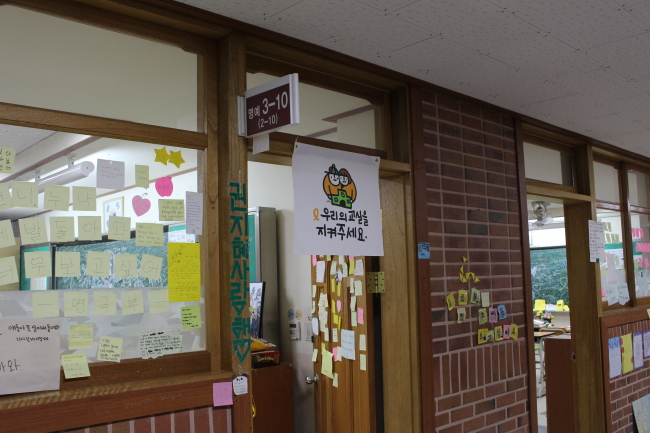 A sign on the door of one of the Memory Classrooms with the message, “Please protect our classrooms.” (Yoon Min-sik/The Korea Herald)