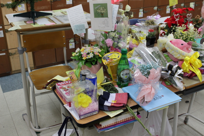 Gifts left by visitors are laid on the desk of Cho Eun-hwa, one of the four students of Danwon High School who remains missing. (Yoon Min-sik/The Korea Herald)