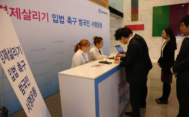 대한상공회의소 등 경제단체가 주도하는 민생입법 촉구를 위한 천만 서명 운동에 이틀간 4만여명이 참여한 것으로 집계되면서 눈길을 끌고 있다. 서명 동참은 계속 이어지고 있다. 서울 세종대로 대한상의 로비에 설치된 ‘경제살리기 입법 촉구 범국민 서명운동’ 부스에서 인근 빌딩 입주 직원들이 서명하고 있다.   [사진제공=대한상의]
