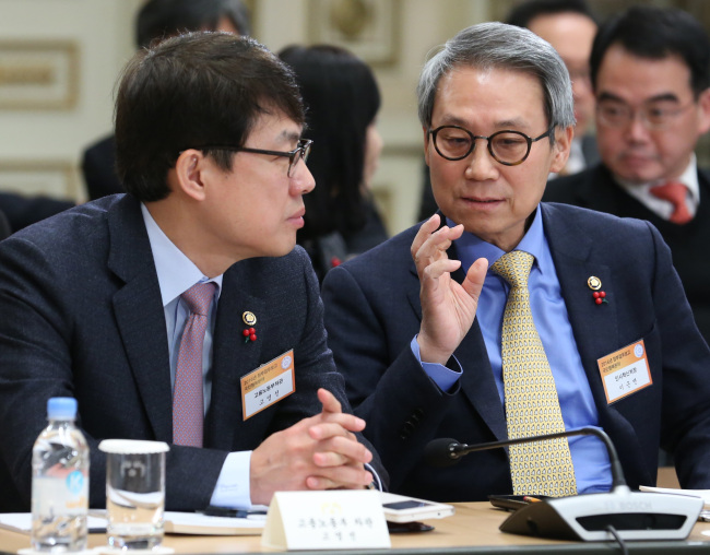 Personnel Management Minister Lee Geun-myeon (right) and Vice Labor Minister Koh Young-sun converse while attending a briefing session at Cheong Wa Dae on Wednesday.  Yonhap