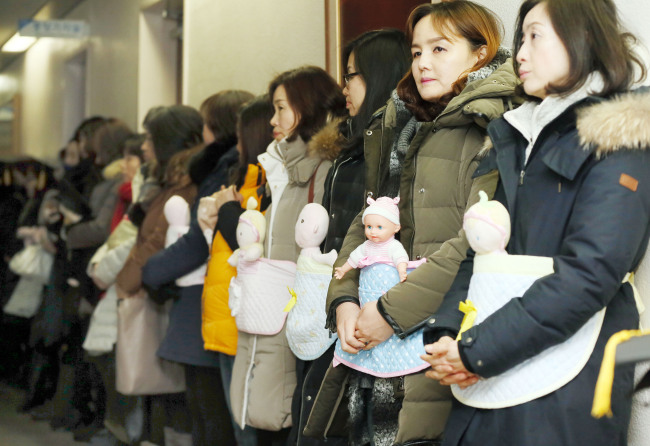 Members of an association of child care centers in Incheon City carry baby dolls as part of a demonstration to call for prompt execution of the Nuri budget by Incheon City and Incheon Metropolitan City Office of Education at Incheon City Hall on Wednesday. Yonhap