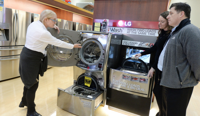 A staffer at a Fry‘s Electronics store in Nevada explains the features of LG Electronics’ Twin Wash washing machine to customers. (LGE)