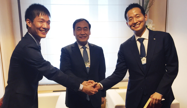 Hanwha Q Cells chief strategy officer Kim Dong-kwan (right) shakes hands with Zhao Haishan (center), vice mayor of Tianjin, China, and Hanwha Life Insurance digital team leader Kim Dong-won during the 2016 World Economic Forum at Davos of Switzerland on Wednesday. Hanwha established a joint venture in Tianjin last year. The two sons of Hanwha Group chairman Kim Seung-youn met global leaders, discussed renewable energy and promoted the company businesses at the forum.   Hanwha Group