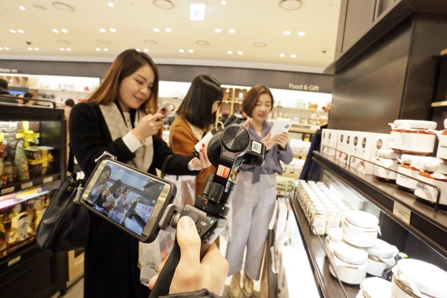 Chinese SNS stars look around Hanwha’s newly-opened duty-free store, located in the 63 building in Yeouido, southwestern Seoul, last Friday. (Hanwha Group)