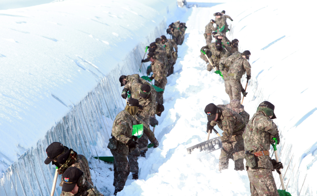 Soldiers clear the snow from greenhouses in Gwangju, Monday. Gwangju saw over 20 centimeters of snow.  Yonhap
