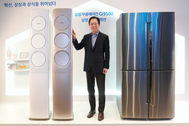 (Photo News) Amid cold spell, Samsung unveils new air conditioner
Samsung Electronics’ home appliance chief Seo Byung-sam poses with the company’s new air conditioner, Q9500, at the Seoul headquarters on Monday. The air conditioner keeps cooling the air via some 135,000 micro holes on the front body once the required temperature is reached, which is the world’s first of its kind. On his right is the Chef Collection premium refrigerator. Samsung Electronics