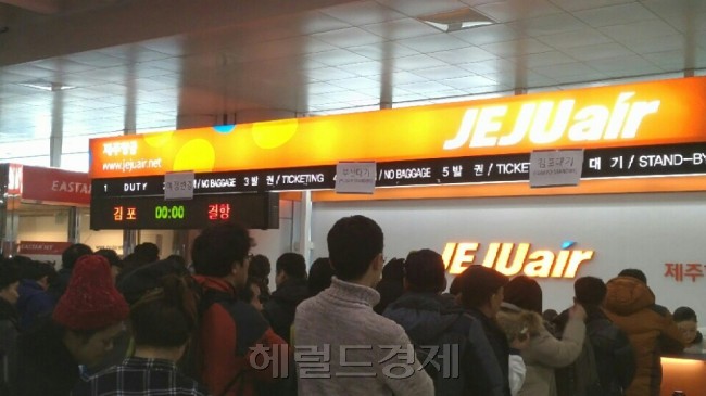 한파가 풀리면서 항공기 운항이 재개된 제주공항에서는 지난 25일 오후부터 26일 오전 6시까지 제주에 발이 묶여 있던 체류객 등 약 2만4000명이 여객기를 통해 뭍으로 나갔다. 지난 25일 제주공항에 있는 체류객들이 한 저비용항공사 발권 창구 앞에서 선착순으로 지급되는 임시편 여객기 대기표를 발급받기 위해 기다리고 있다. 제주=김화균 기자/hkim@heraldcorp.com