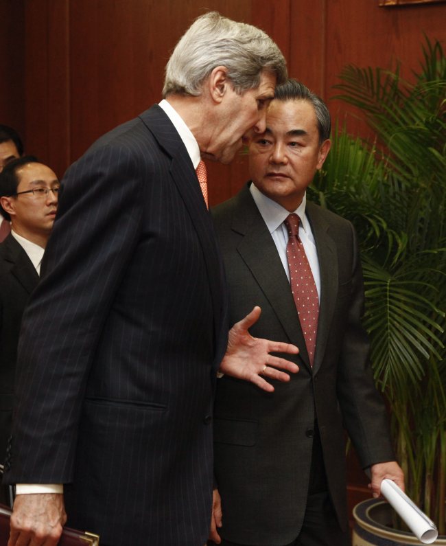 U.S. Secretary of State John Kerry (left) and Chinese Foreign Minister Wang Yi (right) talk to each other before a joint press conference at the Chinese foreign ministry in Beijing, China, on Wednesday. The two officials held talks to boost bilateral ties and discuss issues on the nuclear program of North Korea.
EPA-Yonhap